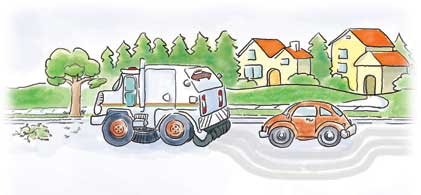 A street sweeper truck and a small orange car drive on a suburban road with trees and houses in the background.