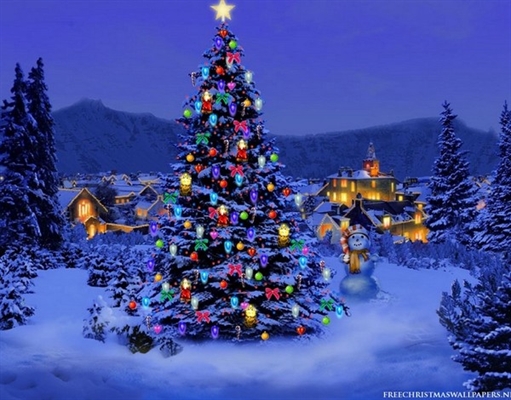 A Christmas tree with colorful lights stands in a snowy landscape near a snowman, with illuminated houses in the background.