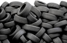 A large pile of stacked black tires arranged in a disorganized manner.